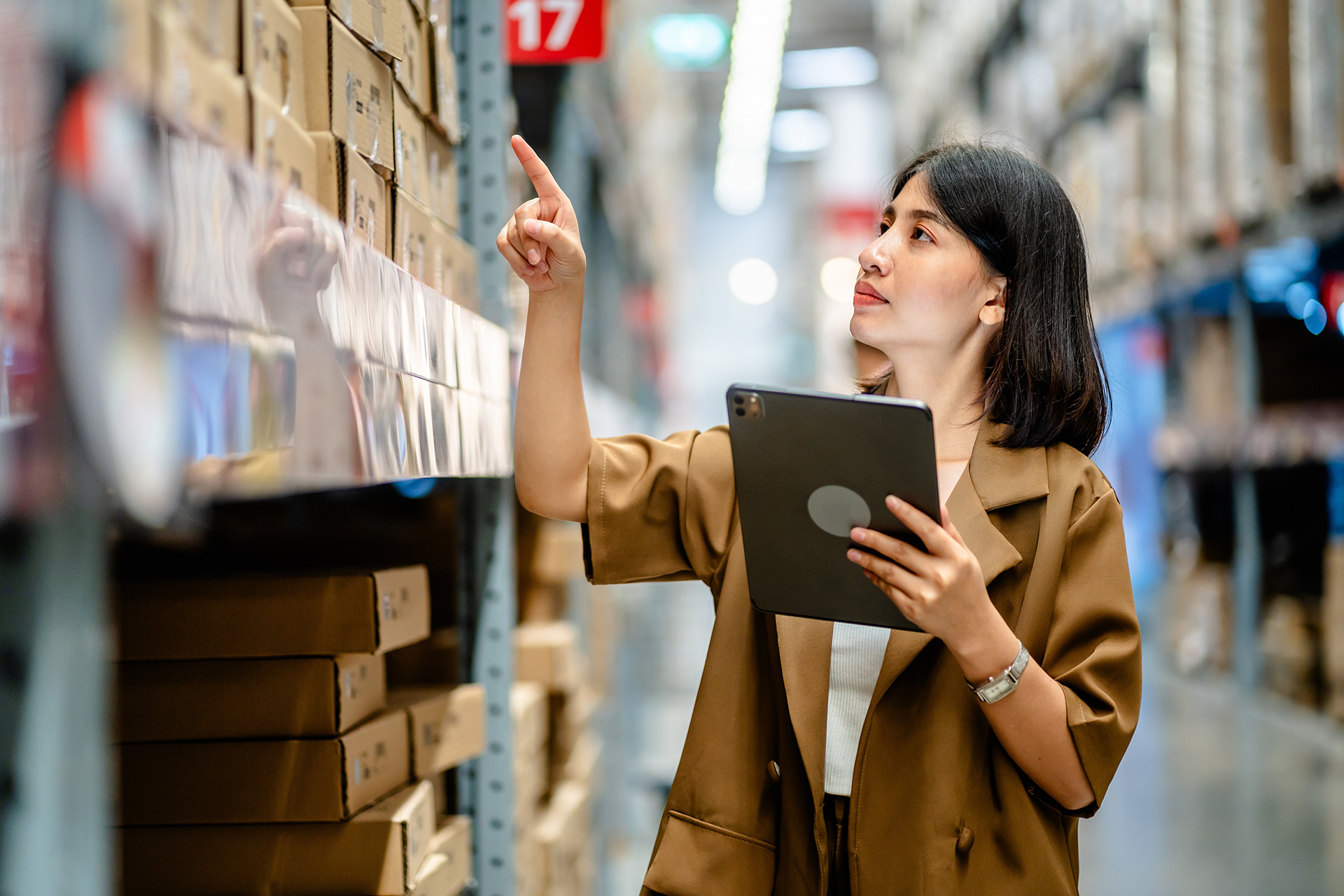 Women warehouse worker using digital tablets to check the stock inventory on shelves in large warehouses, a Smart warehouse management system, supply chain and logistic network technology concept